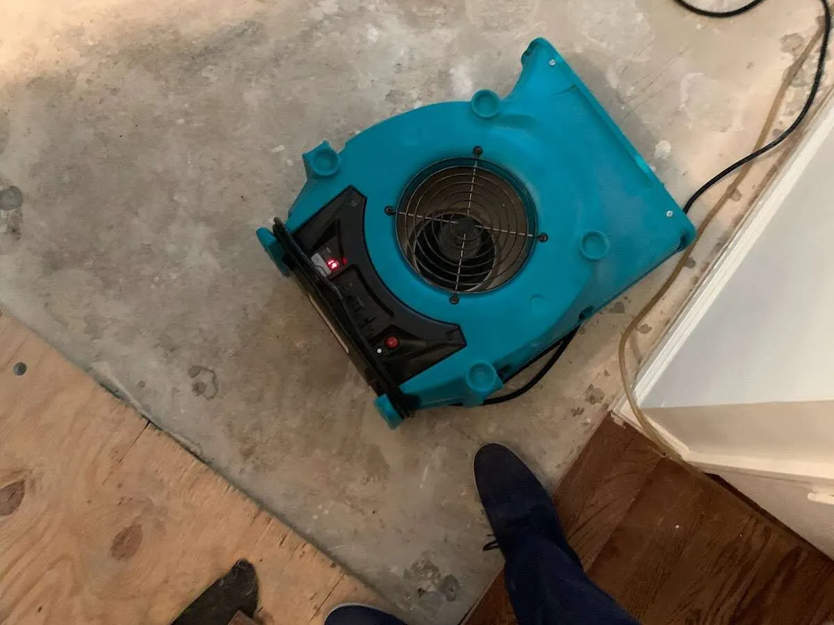 Air mover drying subfloor during Commercial Water Damage Restoration in Aptos